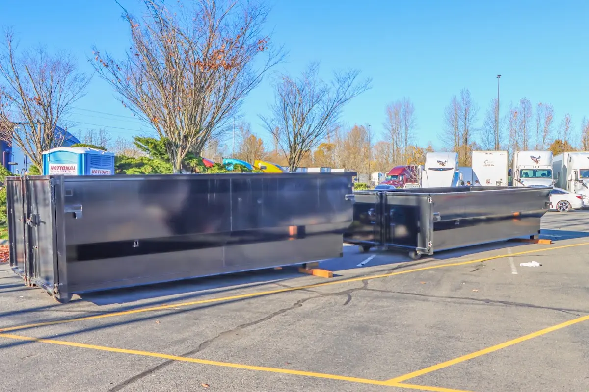 Professional dumpster rental service with roll-off container on residential driveway in East Camden